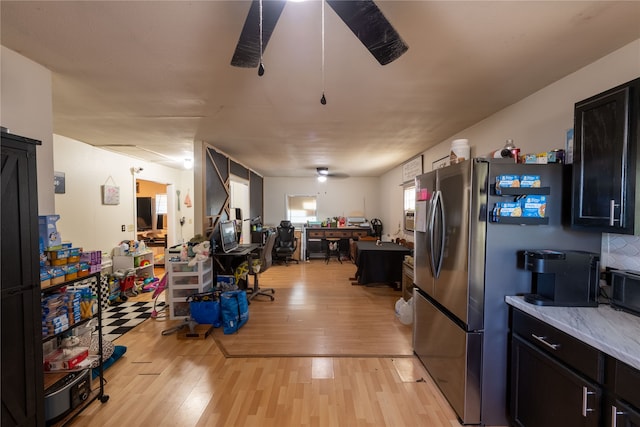 kitchen with light hardwood / wood-style flooring and stainless steel fridge