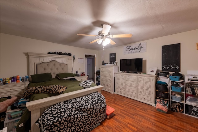 bedroom with hardwood / wood-style floors, a textured ceiling, and ceiling fan