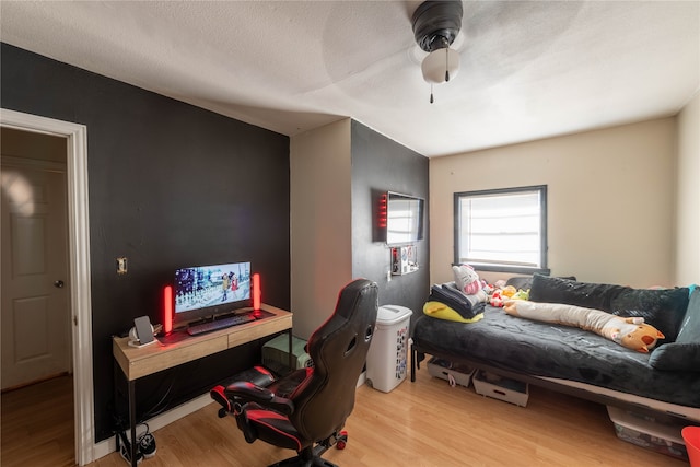 office with a textured ceiling, light wood-type flooring, and ceiling fan