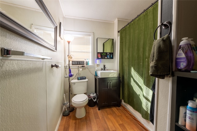 bathroom featuring wood-type flooring, toilet, a shower with curtain, vanity, and crown molding