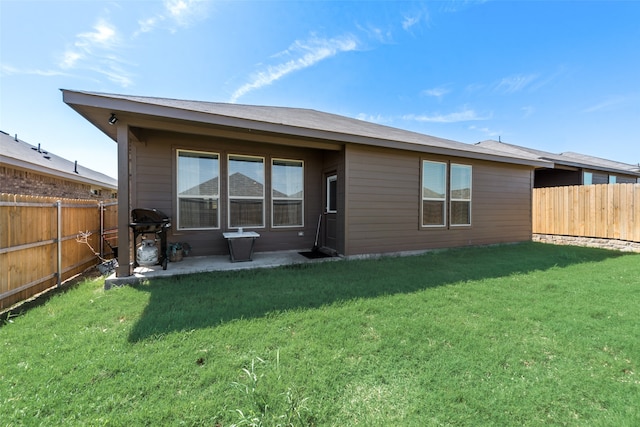 back of house with a yard and a patio area