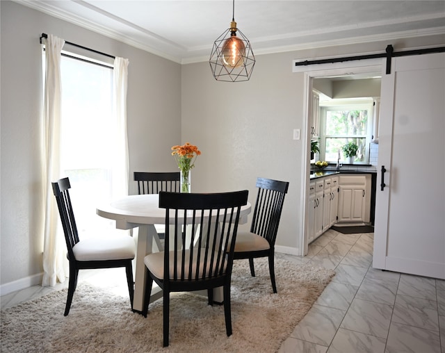 dining space featuring ornamental molding and a barn door