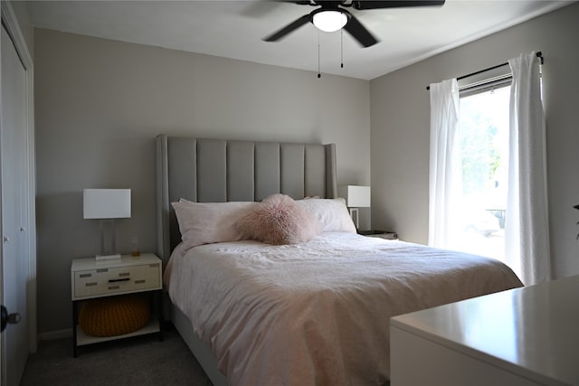 bedroom with dark colored carpet, a closet, and ceiling fan