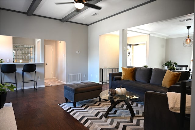 living room featuring crown molding, dark hardwood / wood-style floors, beamed ceiling, and ceiling fan