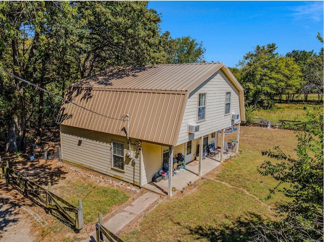 back of house featuring a yard, a patio area, and a wall unit AC