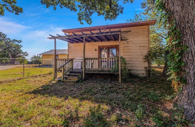 rear view of house featuring a yard and a pergola