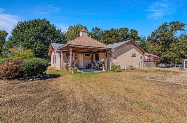 back of house featuring a patio area and a lawn