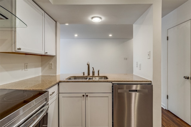 kitchen with kitchen peninsula, stainless steel appliances, sink, white cabinets, and dark hardwood / wood-style flooring