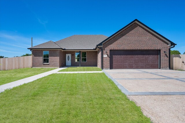 ranch-style house featuring a garage and a front yard