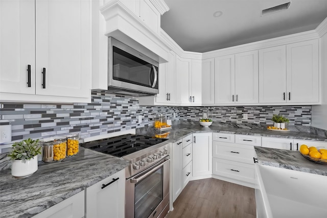 kitchen featuring white cabinets, stainless steel appliances, and backsplash