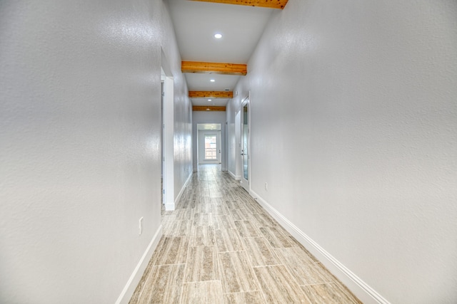 hallway with beamed ceiling and light hardwood / wood-style floors