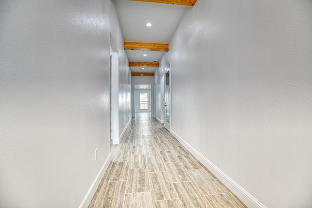 corridor featuring baseboards, recessed lighting, light wood-style floors, and beam ceiling