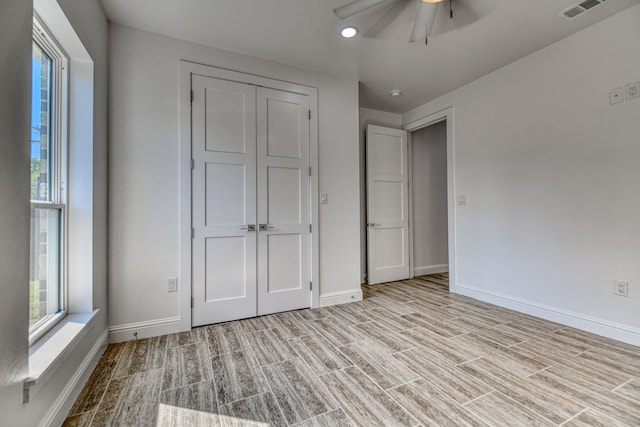 unfurnished bedroom with a closet, light hardwood / wood-style floors, and ceiling fan