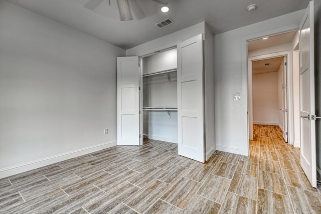 unfurnished bedroom featuring ceiling fan, visible vents, wood finished floors, baseboards, and a closet