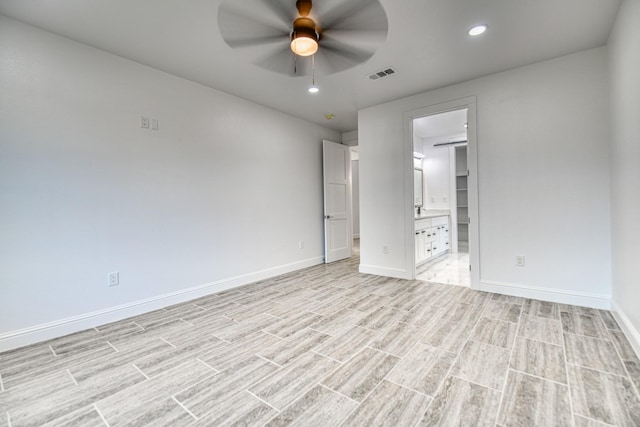 unfurnished bedroom featuring visible vents, baseboards, recessed lighting, light wood-style flooring, and ensuite bath