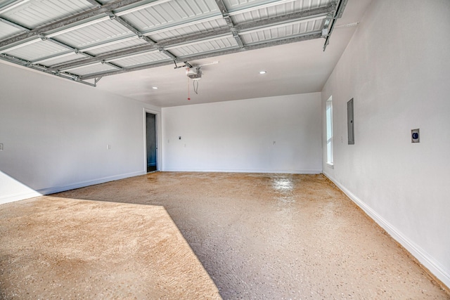garage featuring baseboards, a garage door opener, and electric panel