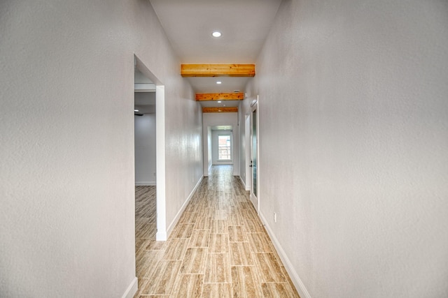 hall featuring baseboards, beamed ceiling, wood finish floors, and recessed lighting
