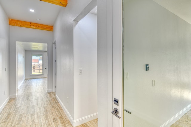 hallway with beam ceiling and light hardwood / wood-style flooring