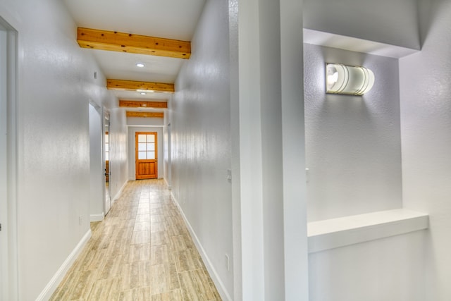 hallway featuring light hardwood / wood-style floors and beamed ceiling