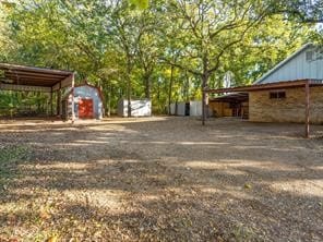 view of yard with a shed and a carport