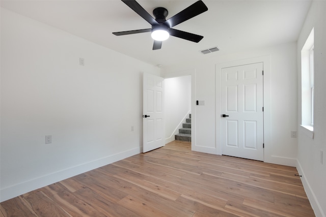 unfurnished bedroom featuring light hardwood / wood-style floors, a closet, and ceiling fan