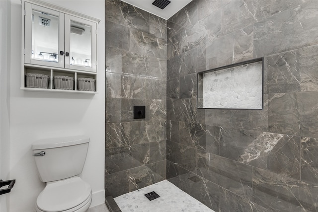 bathroom featuring toilet and tiled shower