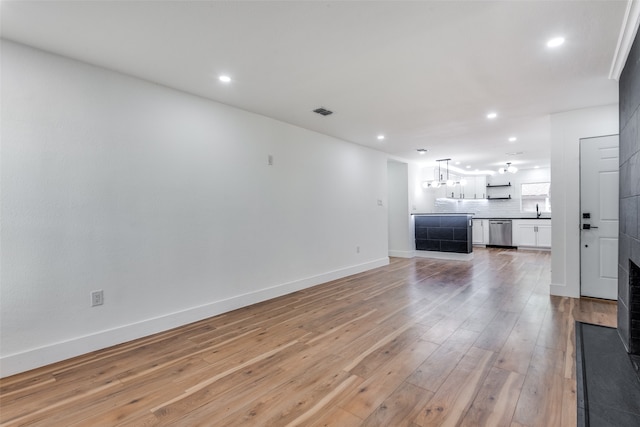 unfurnished living room with sink and wood-type flooring