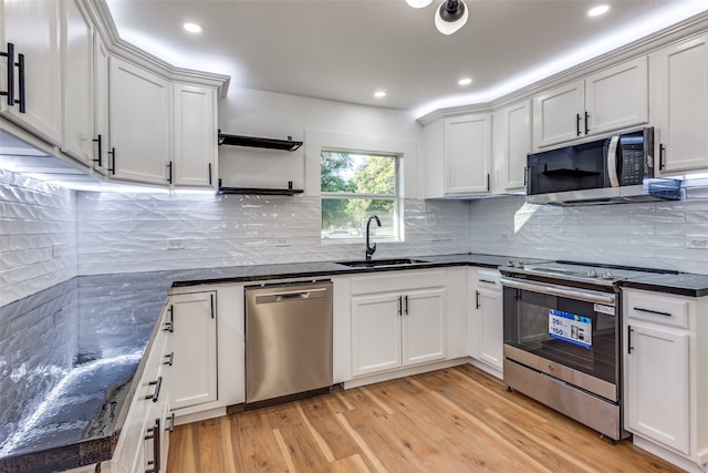 kitchen featuring appliances with stainless steel finishes, sink, and white cabinets