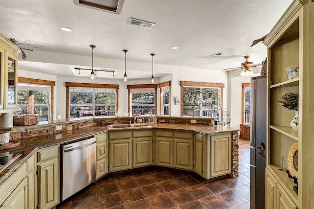 kitchen with sink, dishwasher, cream cabinetry, and hanging light fixtures