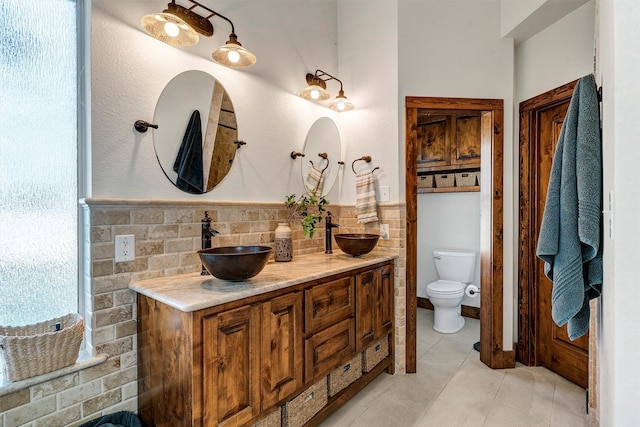 bathroom with vanity, toilet, tasteful backsplash, and tile patterned flooring