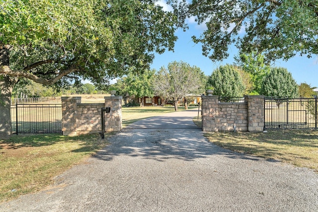 view of gate with a lawn