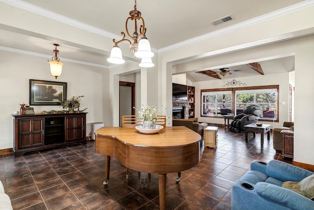 dining room with a stone fireplace, crown molding, beam ceiling, and ceiling fan with notable chandelier