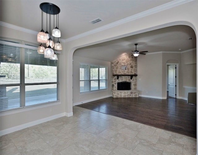 unfurnished living room with light hardwood / wood-style floors, ornamental molding, ceiling fan with notable chandelier, and a fireplace