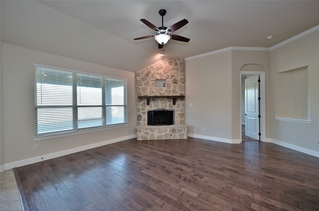 unfurnished living room featuring dark hardwood / wood-style floors, crown molding, vaulted ceiling, a fireplace, and ceiling fan