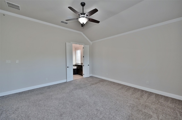 unfurnished bedroom featuring lofted ceiling, ceiling fan, ornamental molding, ensuite bath, and light colored carpet