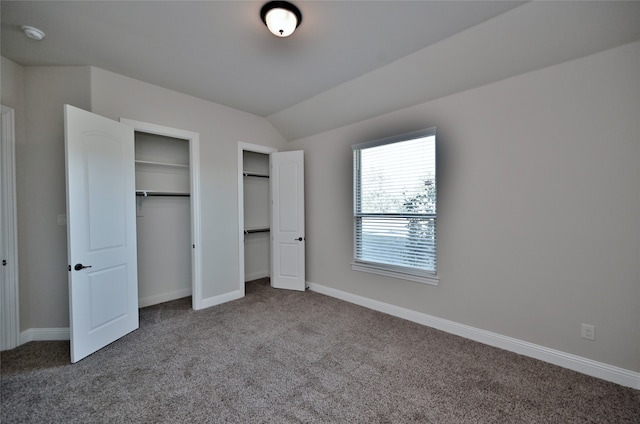 unfurnished bedroom featuring lofted ceiling and carpet