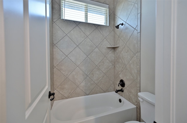 bathroom with tiled shower / bath combo and toilet