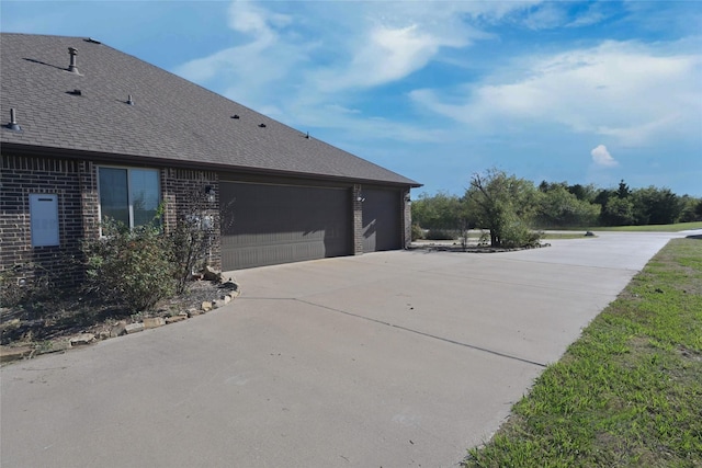 4095 Bridgecreek Dr, Rockwall, TX 75032 - view of side of home featuring a shingled roof, driveway, brick siding, and a garage