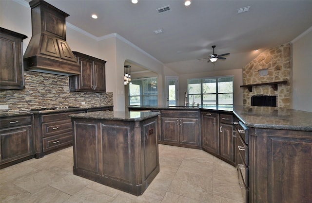 4095 Bridgecreek Dr, Rockwall, TX 75032 - kitchen featuring backsplash, a sink, a kitchen island with sink, custom exhaust hood, and ceiling fan
