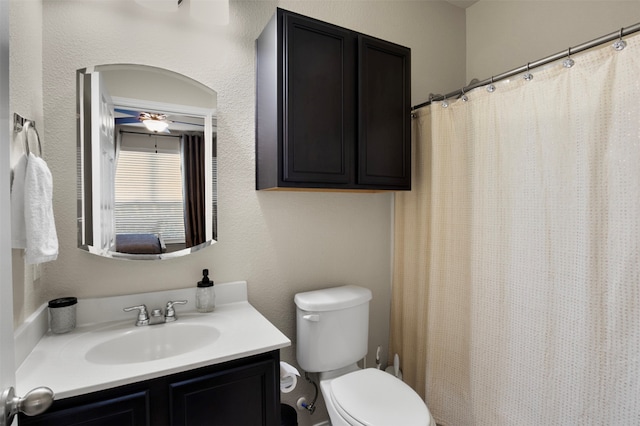 bathroom with vanity, toilet, curtained shower, and ceiling fan