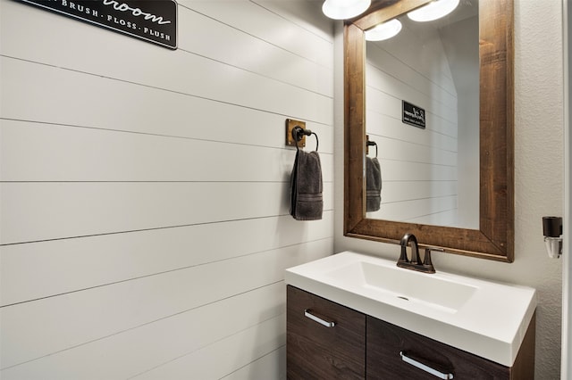 bathroom with vanity and wooden walls