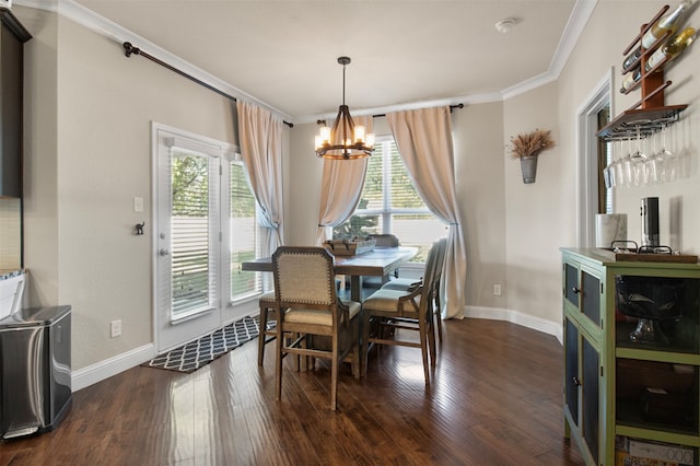 dining area featuring dark hardwood / wood-style flooring, ornamental molding, an inviting chandelier, and plenty of natural light