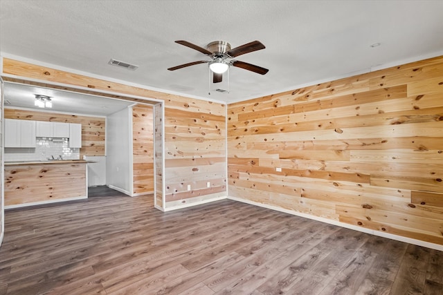 unfurnished room with wood walls and dark hardwood / wood-style flooring