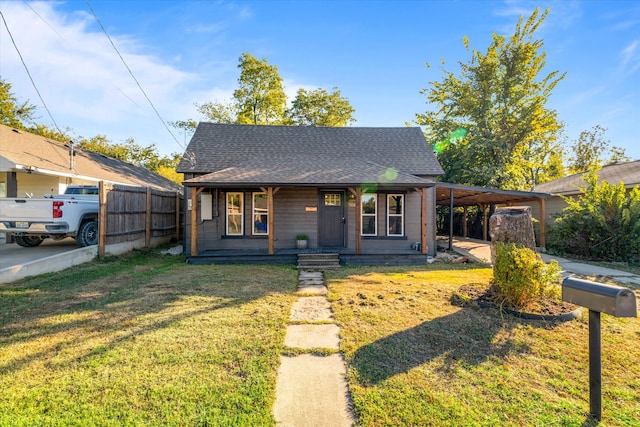 bungalow featuring a porch, a front lawn, and a carport