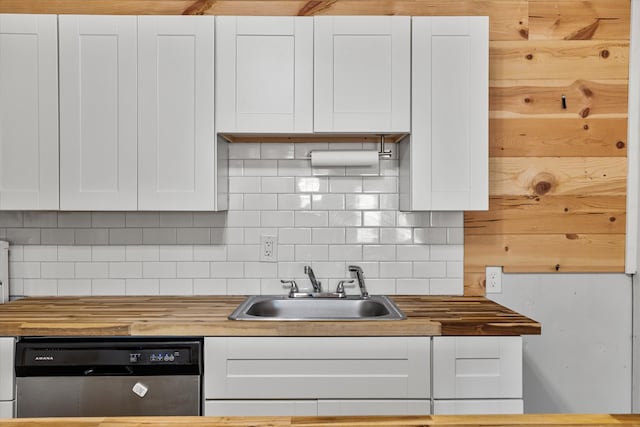 kitchen with stainless steel dishwasher, sink, white cabinets, and wood counters