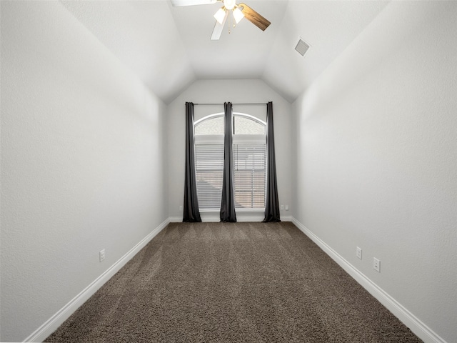 carpeted empty room with visible vents, lofted ceiling, baseboards, and a ceiling fan