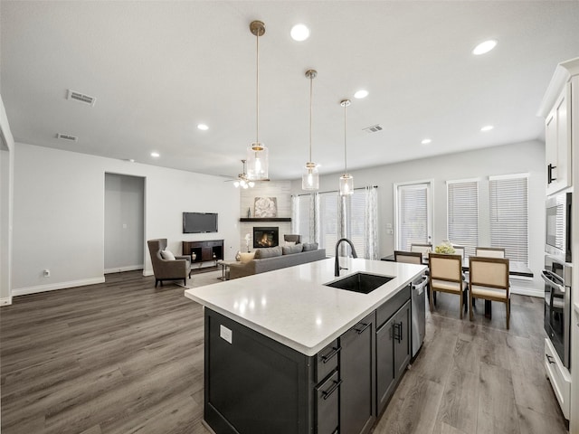 kitchen featuring a sink, stainless steel appliances, visible vents, and a fireplace