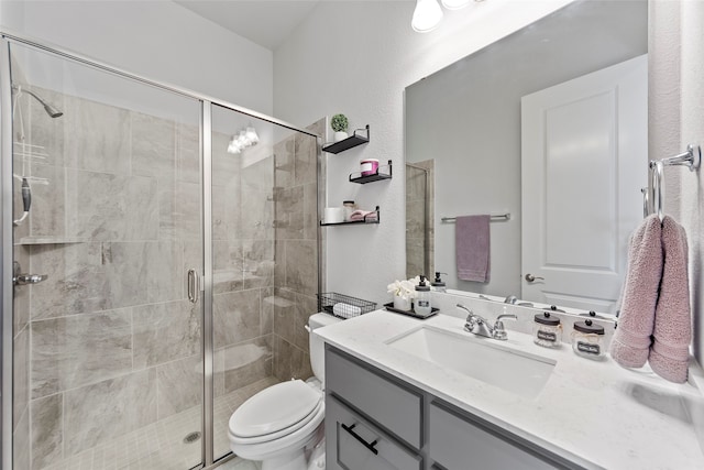 bathroom with a shower with door, vanity, and toilet