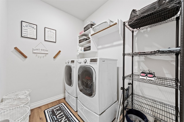 laundry room featuring washing machine and clothes dryer and hardwood / wood-style floors