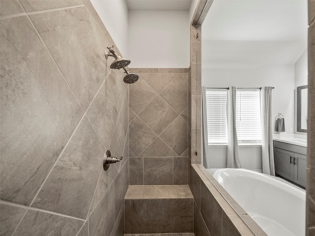 bathroom with vanity, a garden tub, and tiled shower